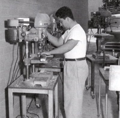 A worker drilling holes for the tuners, '50s.