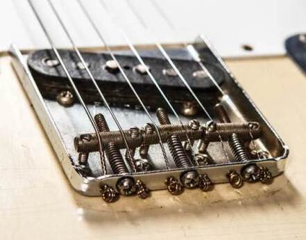 Staggered poles lead pickup and threaded saddles of a late '58 Telecaster. The strings-through-body pattern was suspended and replaced for about a year by a top-loading system.