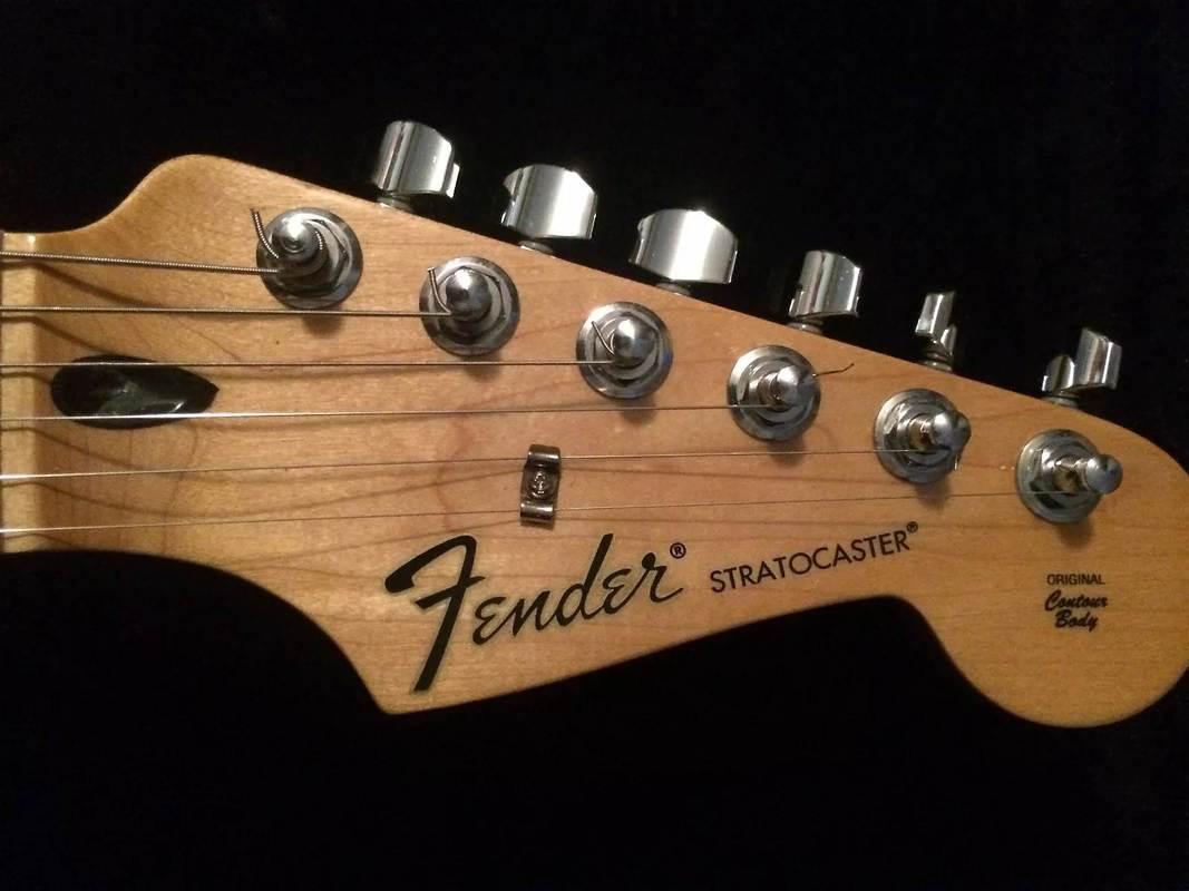 Headstock, Black CBS style Logo and decals of the upgraded Standard Stratocaster. Still the black plastic truss rod access.
